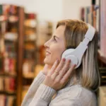 portrait d'une femme portant un casque audio dans une bibliothèque