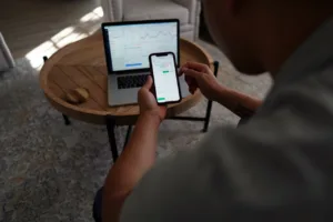 Utilisateur devant un ordinateur avec une application de lancé et la version responsive sur son mobile